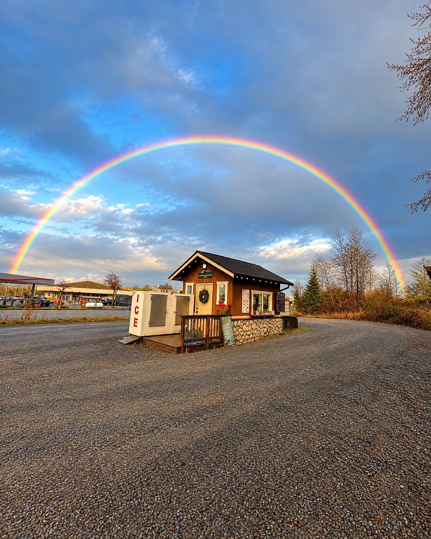 Lord Hill Espresso under a full rainbow in its gravel lot on W Main St